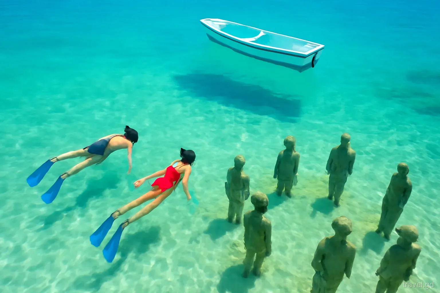 Snorkellers floating above stone figures on a sandy seabed at Molinière Bay, Grenada, small boat moored above, overhead underwater view, clear turquoise water, bright sun